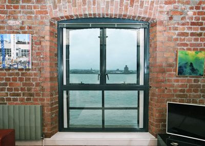 Warehouse conversion apartment with view over harbour through full height windows with Granada Secondary Glazing
